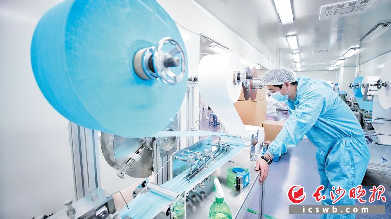 　　湖南三瑞生物科技有限责任公司，工人正在调试口罩生产线。 唐露 摄