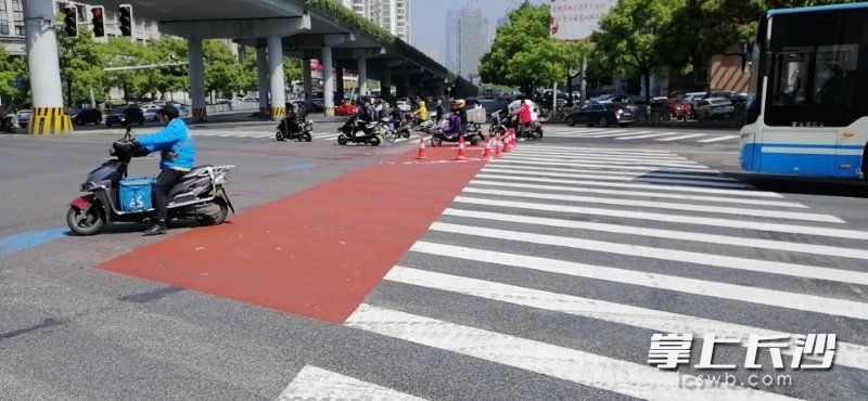 在芙蓉路劳动路口，路面上的红色区域为非机动车“蓄水池等候区”。 天心交警供图