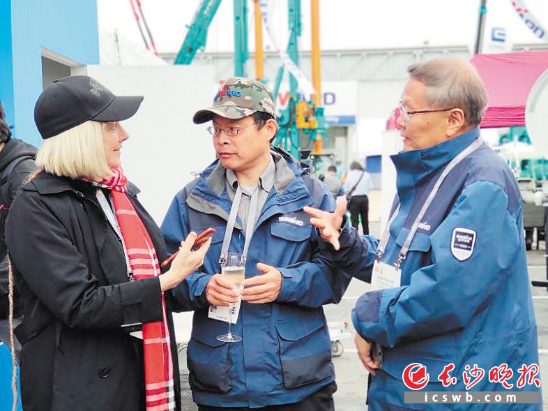 　　何清华（右一）在国外展会现场。          长沙晚报通讯员 彭骏 摄
