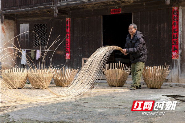 3、竹编制作技艺传承人龙祥庚正在拉竹丝,抖动的竹丝像丝带一样飘舞。.jpg