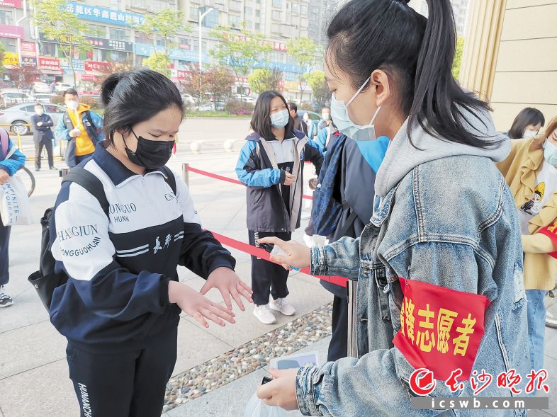 在长郡滨江中学,“雷锋志愿者”们坚守校门,为复学学生开展测温、手部消毒等志愿服务。 市文明办供图
