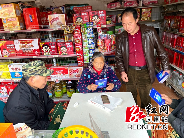 工作人员挨家挨户派发《新冠肺炎疫情防控法律知识简明读本》。.jpg