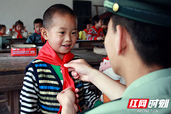 武警官兵在桑植县汨湖乡国营农垦小学给同学们系上新买来的红领巾.jpg