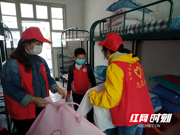 志愿者们协助学生整理床铺.jpg