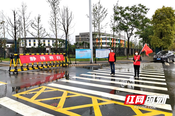 志愿者在郡德学校门口维护治安.jpg