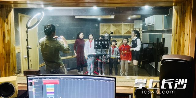 陈明敏老师（左一）在录音棚带孩子们试唱。 通讯员 石亮 摄