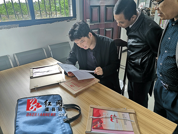 调研组查看扶贫手册等相关资料.gif