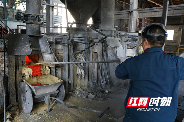 安化渣滓溪冶炼厂精炼工段反射炉车间炉前工正在刨碱渣_meitu_2.jpg