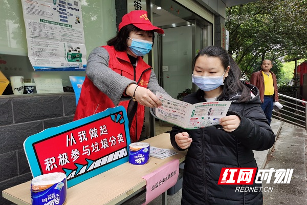 志愿者为居民发放垃圾分类投放指南.jpg