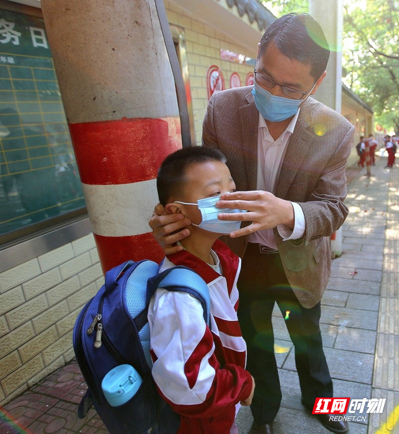 0200427第十一完全小学清晨，学校老师引导学生有序入校8老师教学正确戴好口罩.jpg