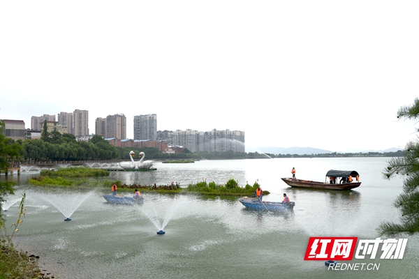 近日，岳阳市南湖新区千亩湖，巡湖保洁员在清理湖面漂浮物并喷射高效环保微生物菌剂净化水质。（谢少杰 摄）.jpg