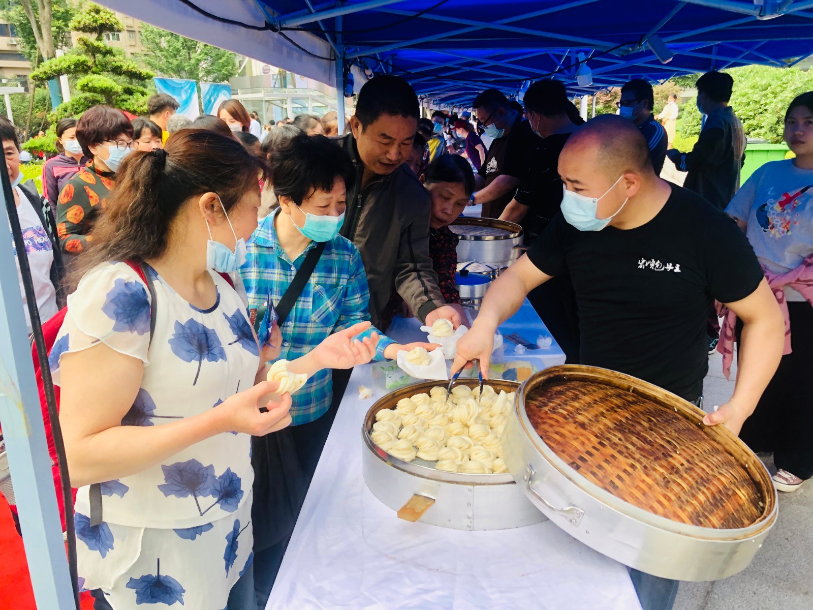 “湖南好人”吴鑫成（右）的带了20余笼包点，免费送给市民尝鲜。 全媒体记者 李卓 摄