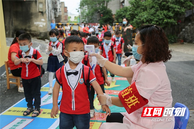 4、2020年5月11日，湖南省永州市零陵区机关幼儿园，校医给学生测体温。（潘爱民摄）.jpg