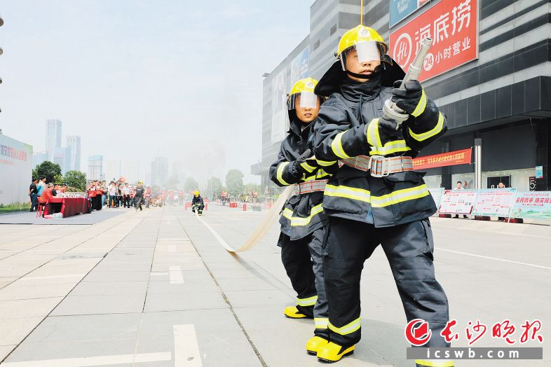 11日，開福區(qū)應(yīng)急管理局、芙蓉北路街聯(lián)合主辦微型消防站大比武暨應(yīng)急救援演練，來自芙蓉北路街道7個(gè)社區(qū)、世紀(jì)金源置業(yè)購物中心、世紀(jì)金源物業(yè)管理微型消防隊(duì)共9支隊(duì)伍同臺(tái)競技，針對原地著消防救援服、定點(diǎn)滅火、水帶連接操以及人員密集場所和高層住宅火災(zāi)救援疏散等關(guān)鍵環(huán)節(jié)開展練兵比武。李文 攝