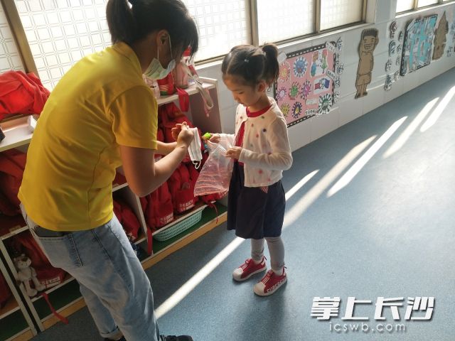老师指导和帮助小朋友把口罩取下并专用自封袋装好。
