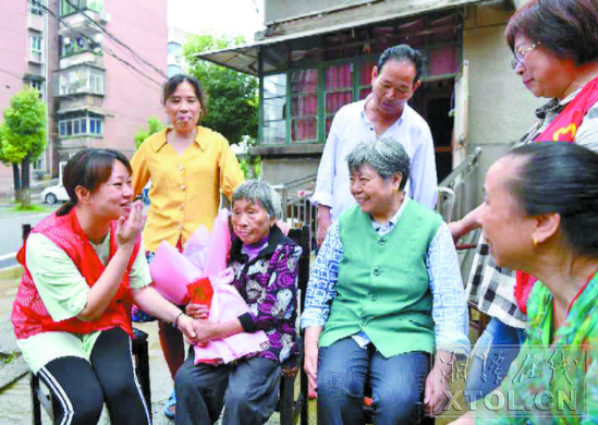 社区工作人员、亲戚、邻居为百岁老人刘凤秀（前排左二）送上祝福。（本报记者 陈旭东 摄）