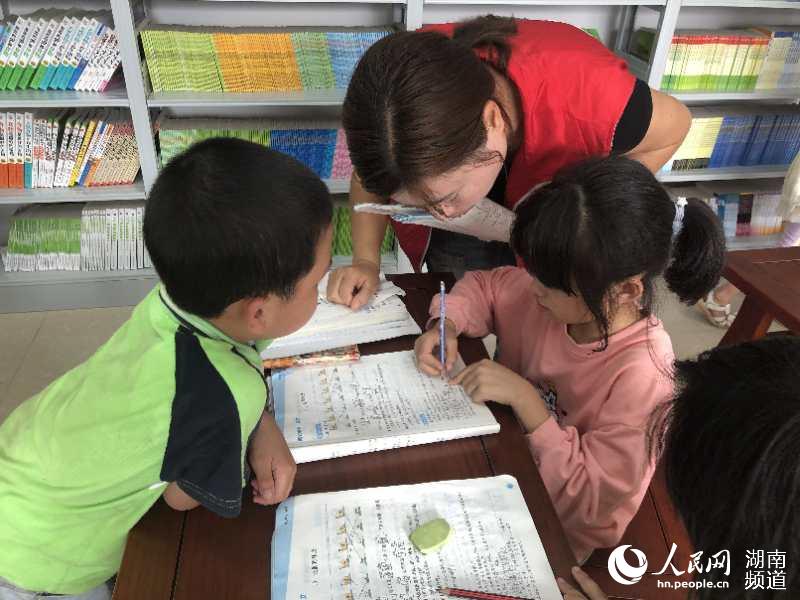 四点半课堂上志愿者为搬迁户孩子辅导作业。雷国媛 摄