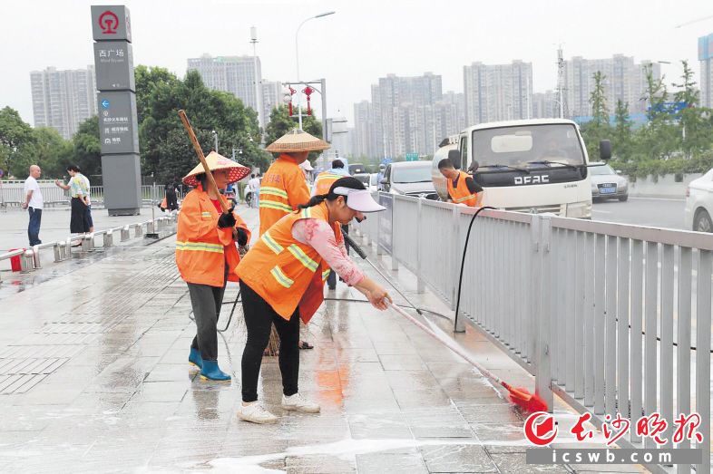 　　7月3日，在长沙火车南站，环卫工人们在认真清洁路面和护栏。   长沙晚报通讯员 高思玥 摄