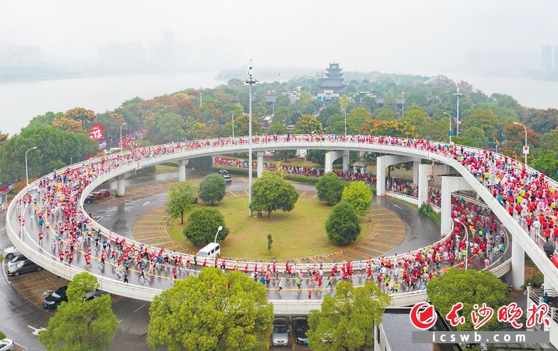 　　2019年长沙马拉松雨中开跑，来自15个国家和地区的23867名跑友汇成一道红色的海洋驰骋在山水洲城。 　　邹麟 摄
