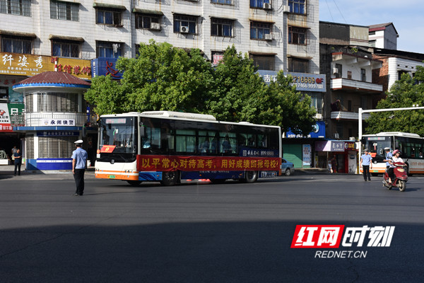 交警指挥社会车辆让行，引导送考车经过十字路口。.jpg