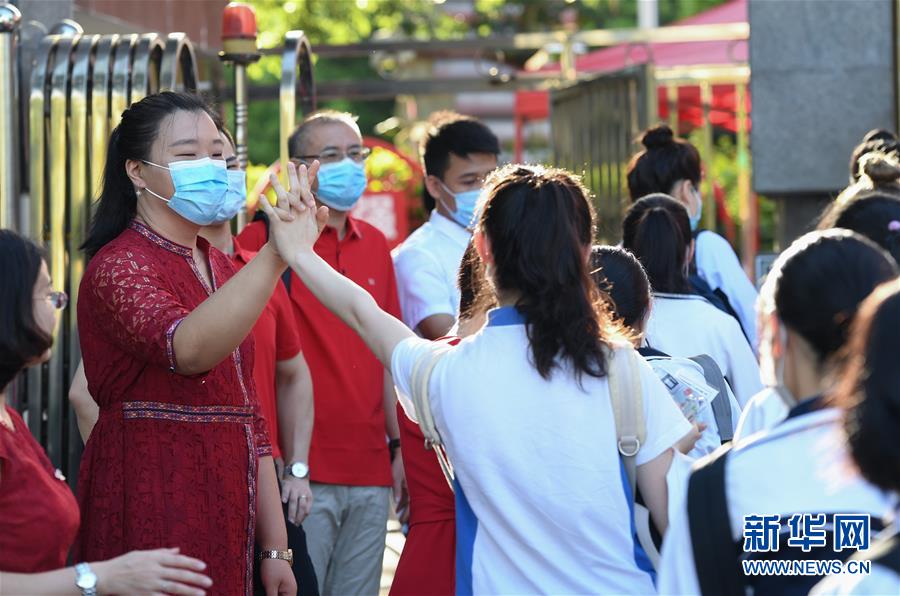 7月7日，在深圳市福田中学考点外，老师为即将参加高考的考生加油。 当日，2020年高考拉开帷幕。 （新华社）
