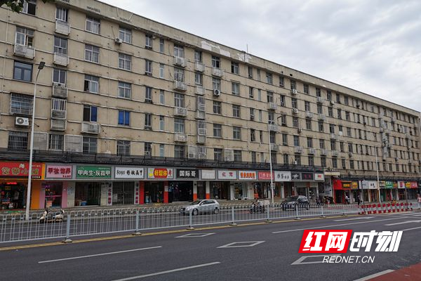 从拆除雨棚后的楼栋下路过的居民显得格外安心_副本.jpg