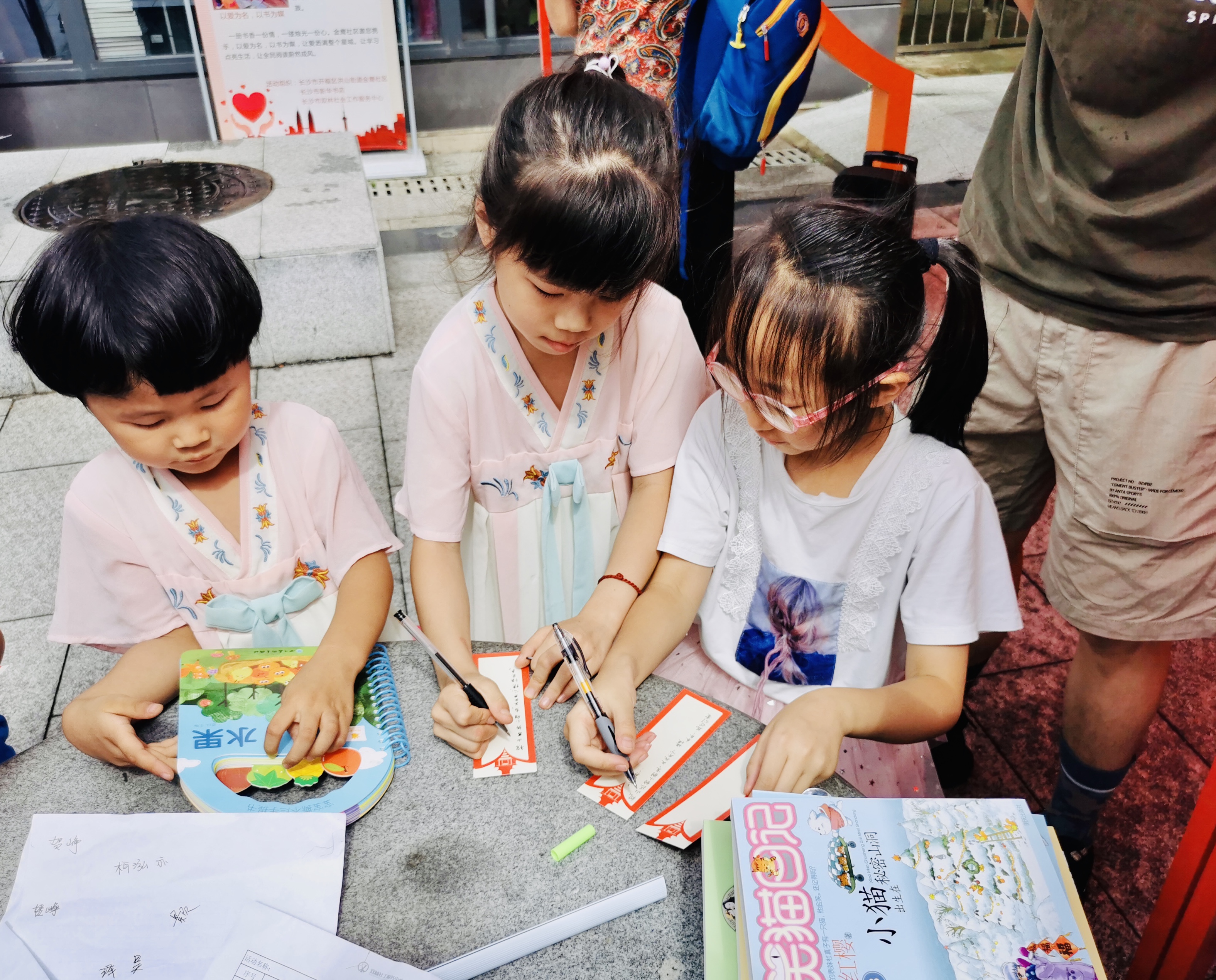 孩子们买书后在“红书签”上签名赠书。 全媒体记者 李卓 摄