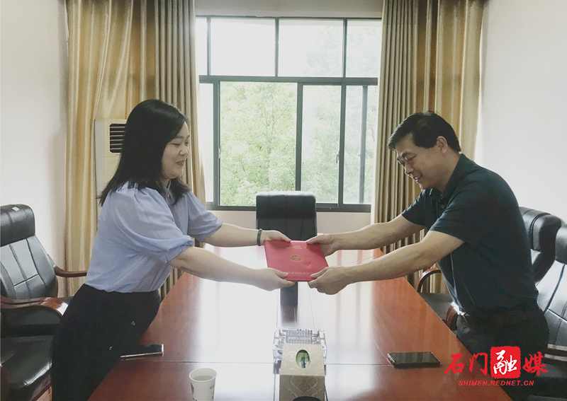 石门县妇联党组书记、主席许婧为县司法局党组书记、局长刘波现场颁发荣誉证书.jpg