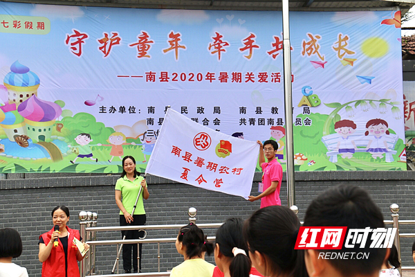 南县妇联负责人为南县暑期农村夏令营授旗.jpg
