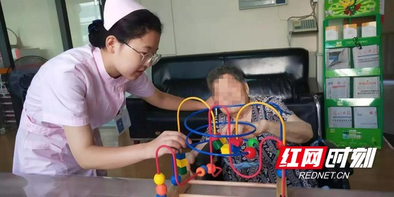 在医护人员的引导下，这位娭毑正在玩有助于康复的器械.wm.jpg
