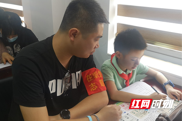 志愿者辅导小朋友完成测试.jpg