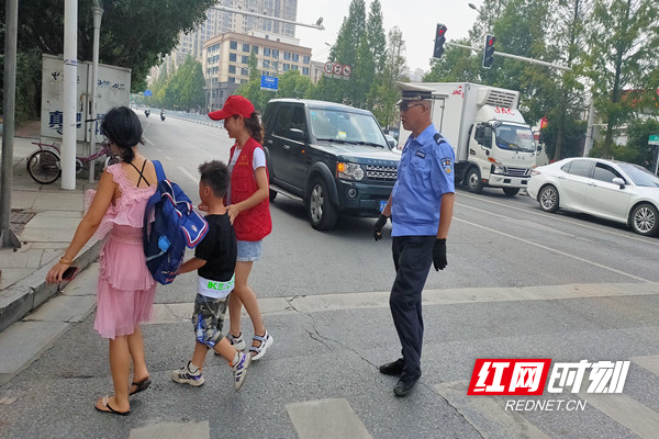 志愿者和民警给家长和孩子过马路保驾护航.jpg