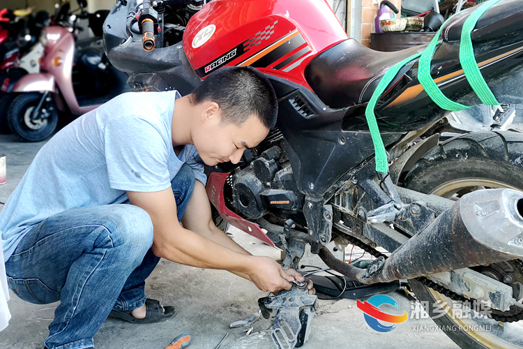 月山镇白龙村建档立卡贫困户刘太白在修理摩托车。.jpg