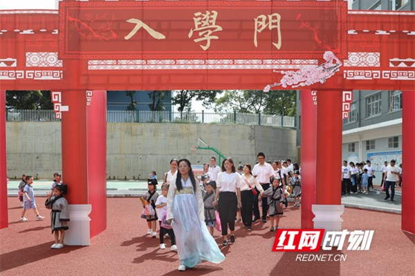 杨新星带着新入学的孩子们走过“入学门”。.jpg