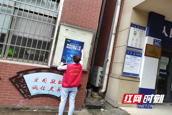 志愿者在辖区宣传栏张贴网络安全宣传周海报.jpg 志愿者在辖区宣传栏张贴网络安全宣传周海报.jpg