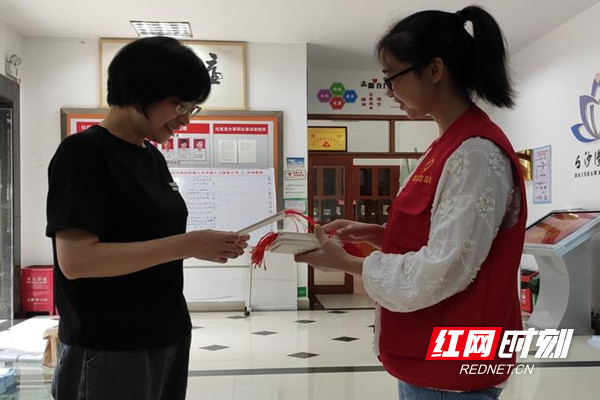 志愿者为来社区办事的居民发放网络安全宣传特色书签.jpg 志愿者为来社区办事的居民发放网络安全宣传特色书签.jpg