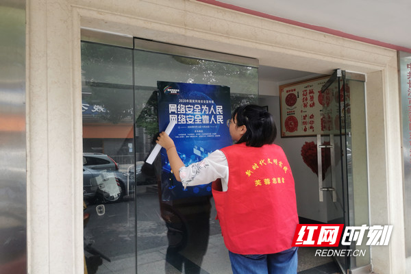 新时代文明实践站志愿者张贴宣传海报.jpg