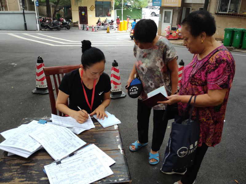 党员志愿者正在网格小区设点登记人口信息.png