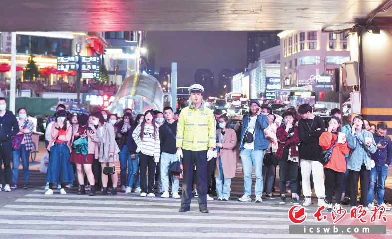　　10月3日晚，五一广场黄兴路口，一位交警正在维护交通秩序，确保市民游客在假日有愉快的出行体验。