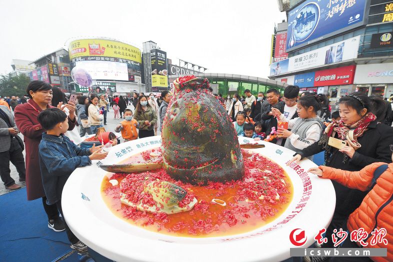 　　在黄兴广场，商家布置的超大份剁椒鱼头吸引了众多游客驻足。