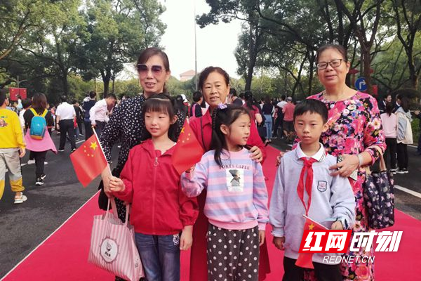志愿者将小红旗发放给升旗仪式现场的居民群众。_副本.jpg