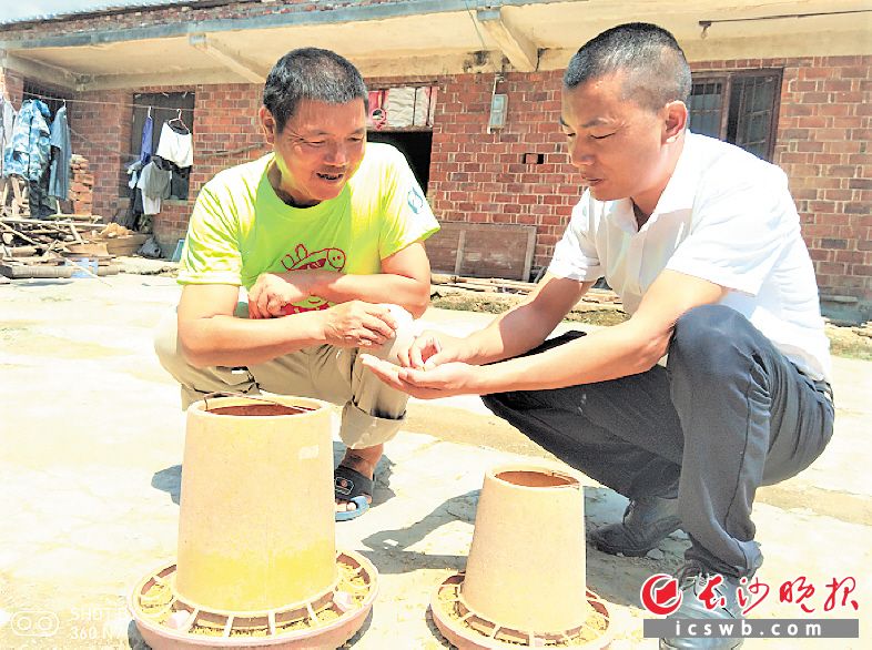 　　在喻家坳乡高田村，驻村帮扶第一书记邹健（右一）走访了解贫困户家的养殖情况。