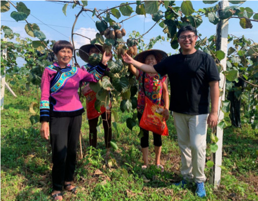扶贫工作队员曾鹏（右 1）与在百亩生态猕猴桃产业示 范园顶着烈日劳作的村民一起庆祝丰收。.png