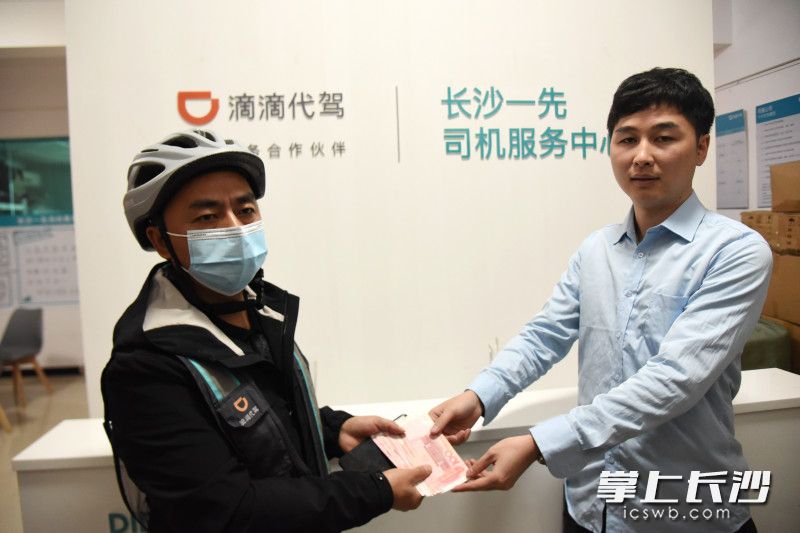 10月20日，滴滴代驾司机李红旺（左）获得公司的800元现金奖励。长沙晚报全媒体记者 刘琦 摄
