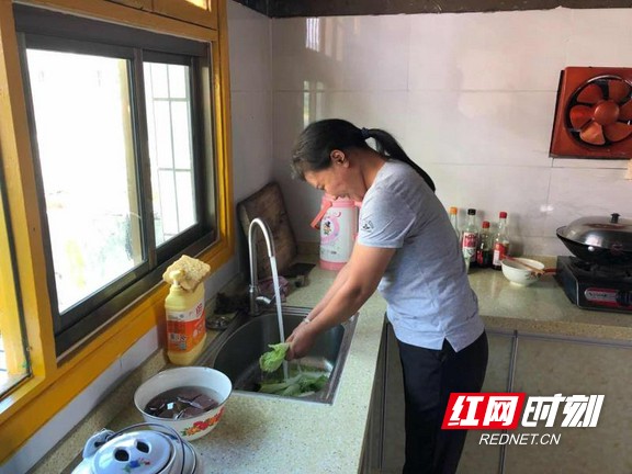 漆赛兰正满脸笑容地在家用干净的自来水清洗蔬菜。.marked.jpg