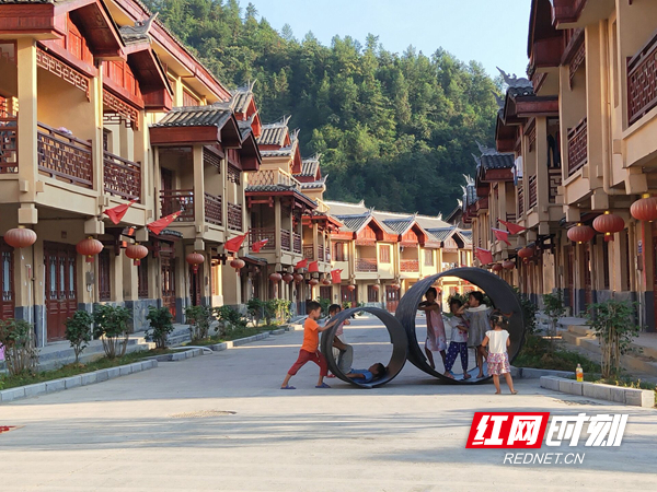 禾库镇搬迁户搬迁到安置区之后的建档立卡户子女有了新乐园，过上了新生活。图为孩子们在干道上嬉戏玩耍.jpg