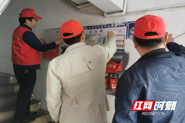 志愿者清理墙体广告和张贴文明宣传牌.jpg 志愿者清理墙体广告和张贴文明宣传牌.jpg