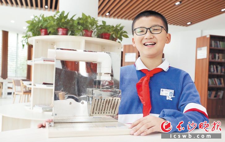 　　张荣景和他的防倒灌油烟装置。市文明办供图