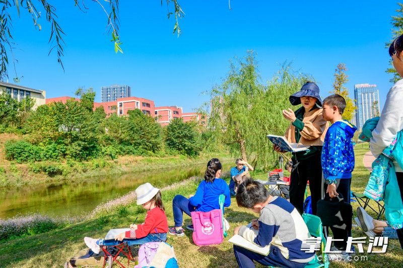 圭塘河畔，一群小朋友正在老师带领下，将圭塘河美景绘进自己画作里。长沙晚报全媒体记者 陈飞 摄01