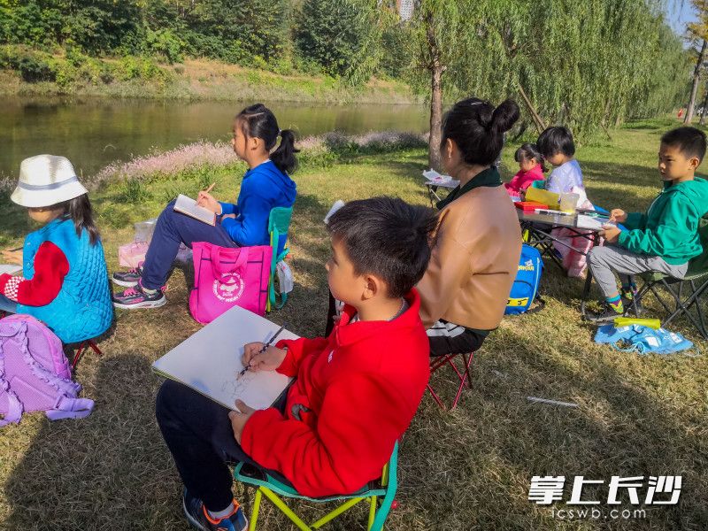 圭塘河畔，一群小朋友正在老师带领下，将圭塘河美景绘进自己画作里。长沙晚报全媒体记者 陈飞 摄